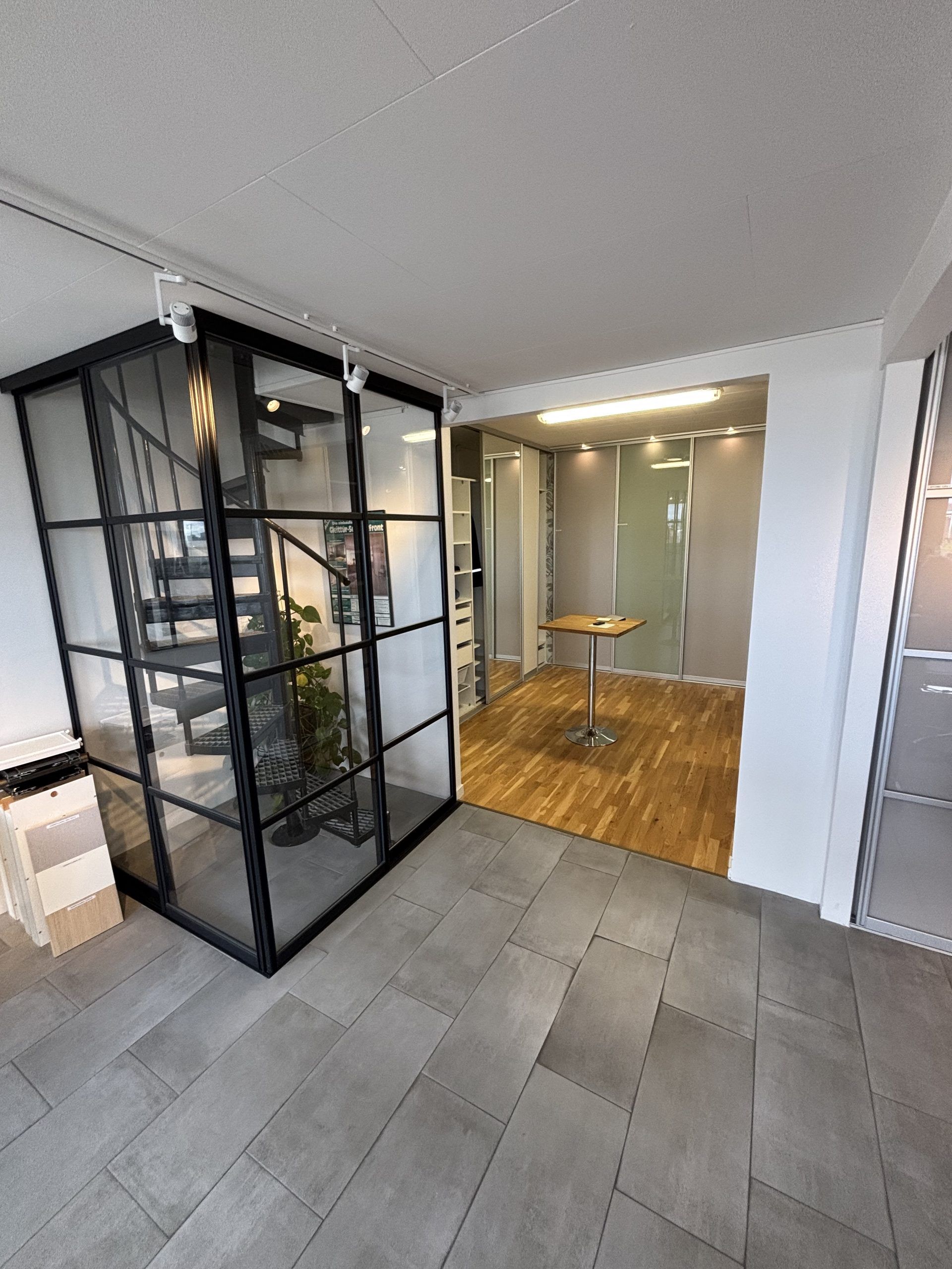 Black-framed glass around a spiral staircase, showroom