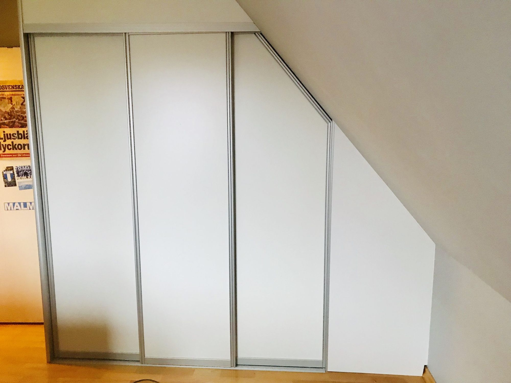 White sliding doors with angled top under slope
