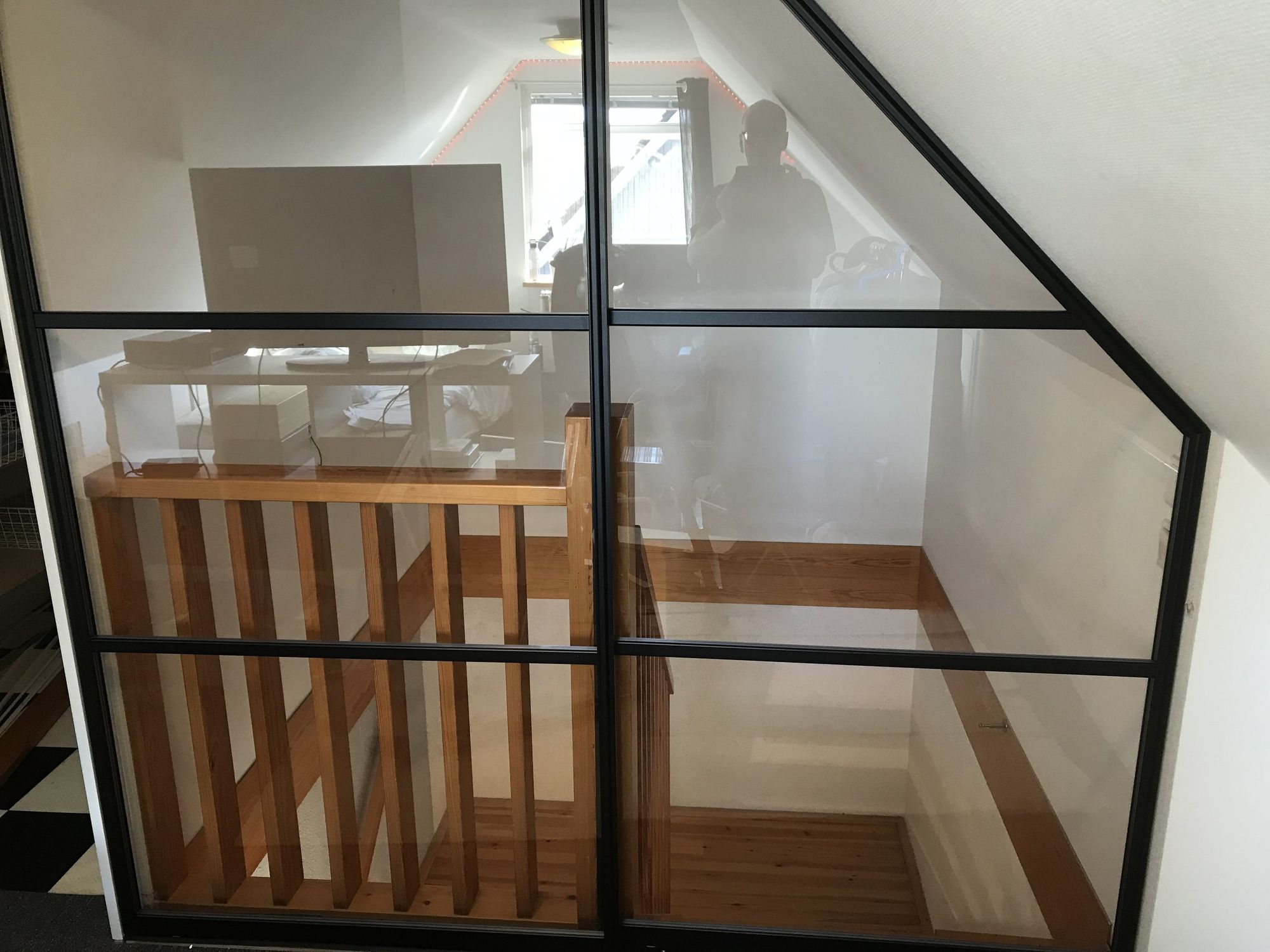 Black-framed glass wall over a stair opening