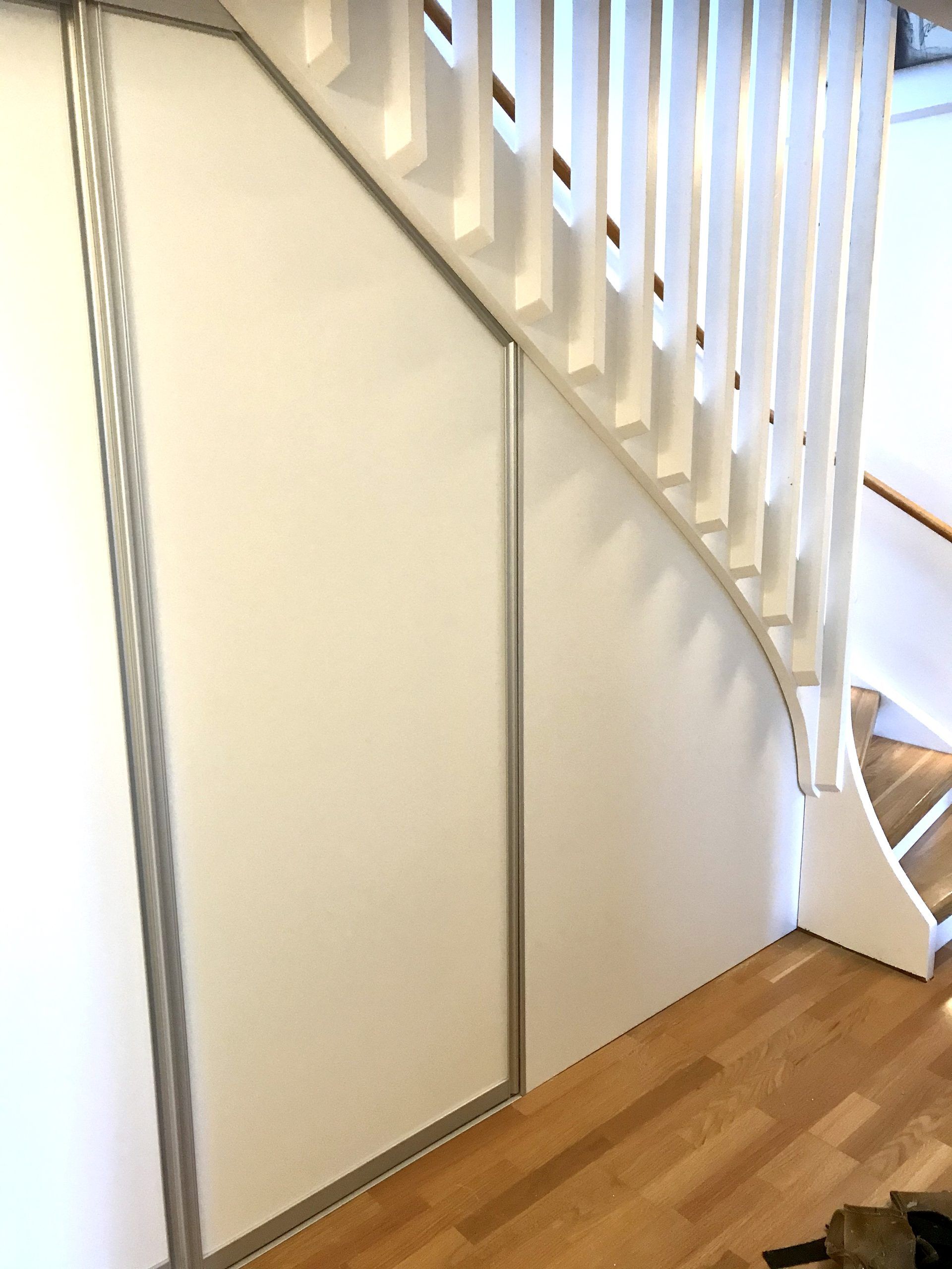 Beige doors below a curved staircase