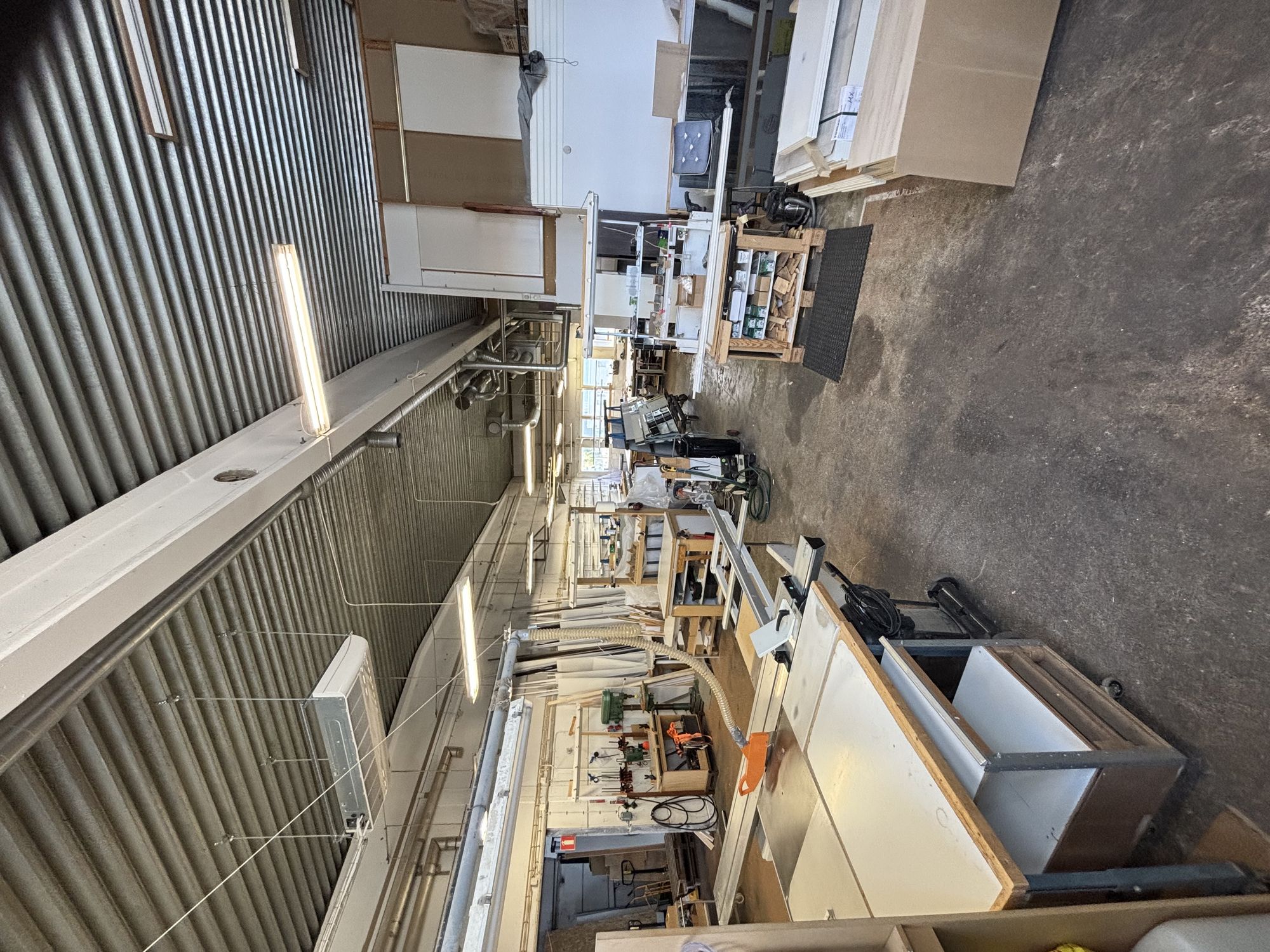 Roland Systems verkstad i Malmö med arbetsbänkar, maskiner och material