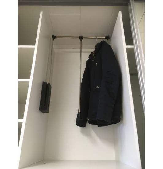 Fold-down clothes rail pulled down inside a white wardrobe section, with a black jacket hanging on it.